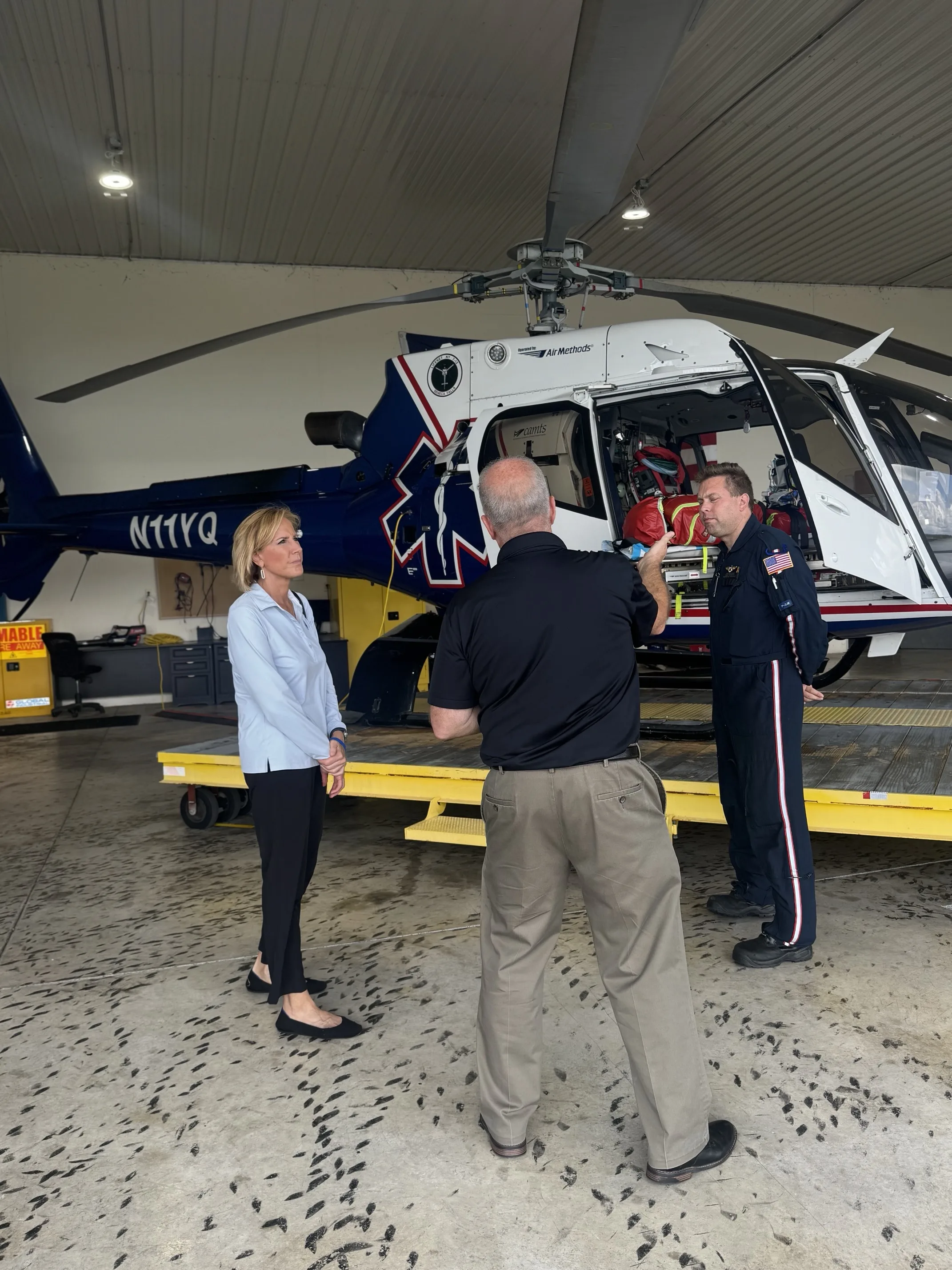staff providing a medical helicopter tour and equipment demonstration at an Air Methods facility.