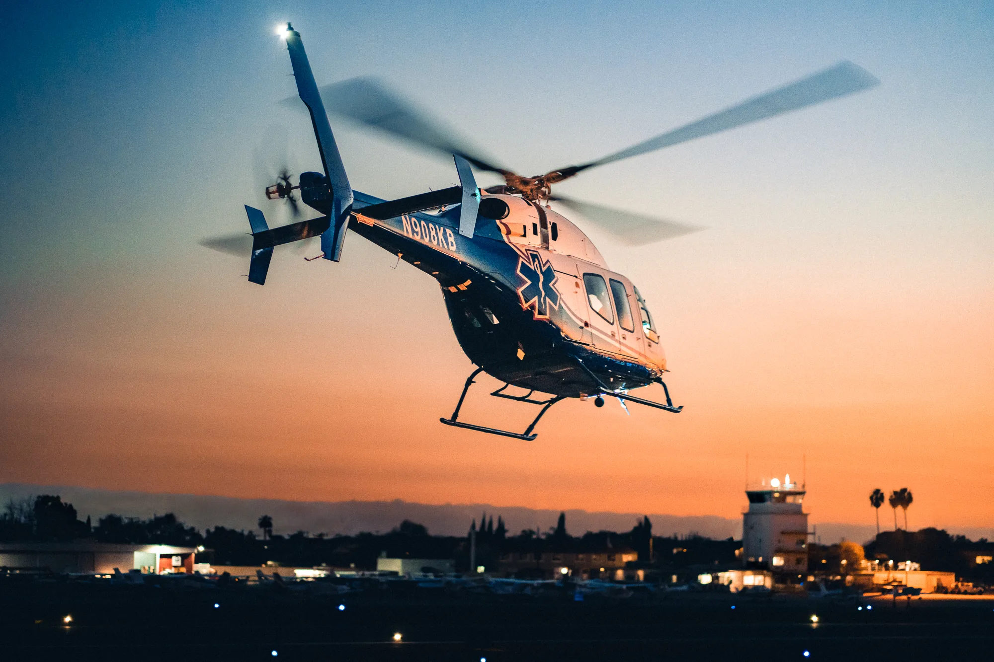 A medical transport helicopter in flight at dusk.